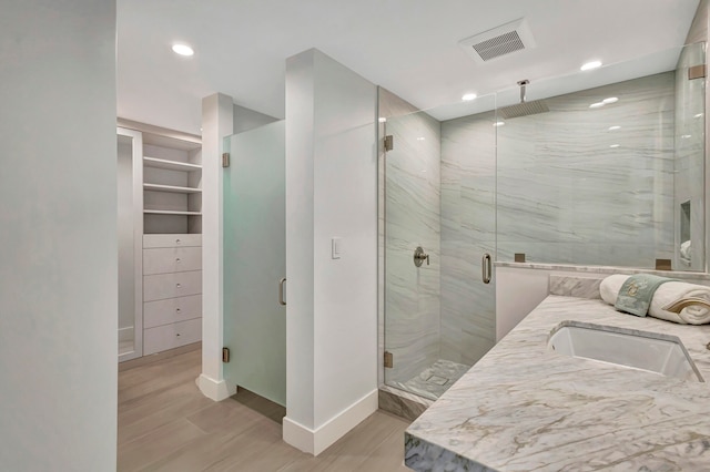 bathroom featuring sink and a shower with shower door