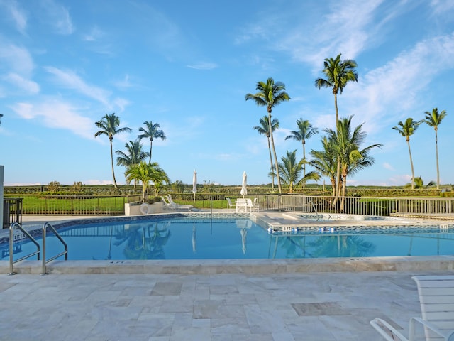 view of swimming pool featuring a hot tub and a patio