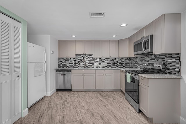 kitchen featuring tasteful backsplash, gray cabinets, and stainless steel appliances