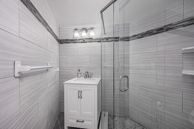 bathroom featuring tile walls, walk in shower, and vanity