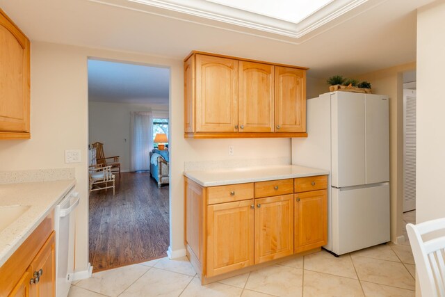 kitchen featuring light wood-type flooring, light stone counters, and white appliances