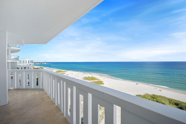 balcony featuring a beach view and a water view