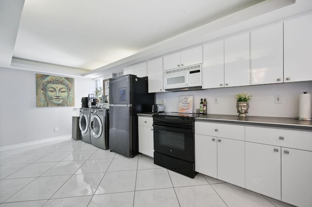 kitchen with washing machine and clothes dryer, a tray ceiling, white cabinetry, black appliances, and light tile patterned flooring