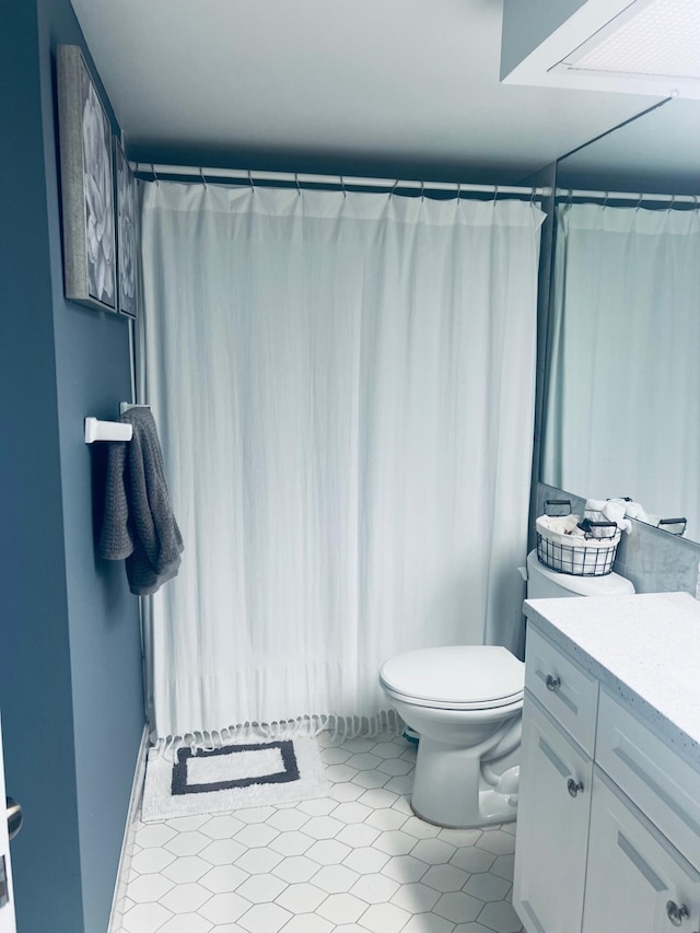 bathroom featuring tile patterned flooring, vanity, and toilet