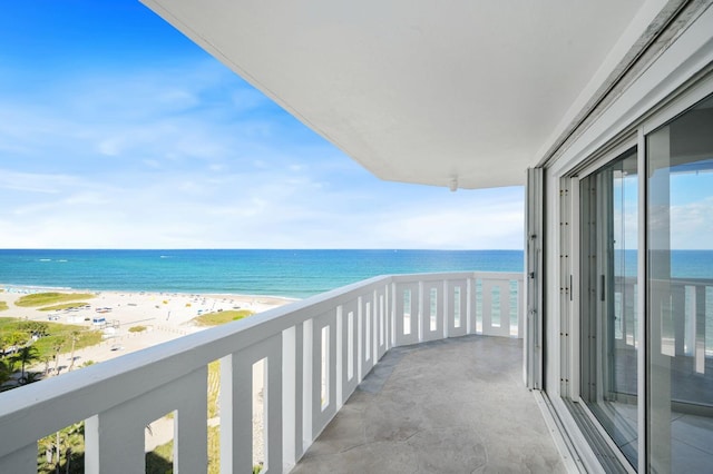 balcony featuring a view of the beach and a water view