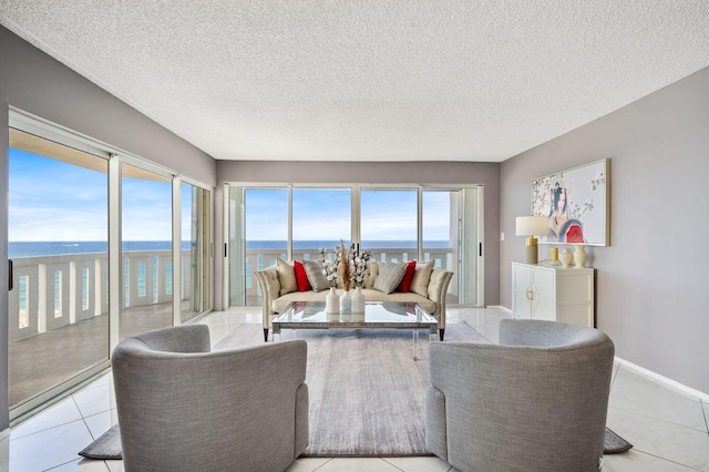 tiled living room with a textured ceiling and a water view