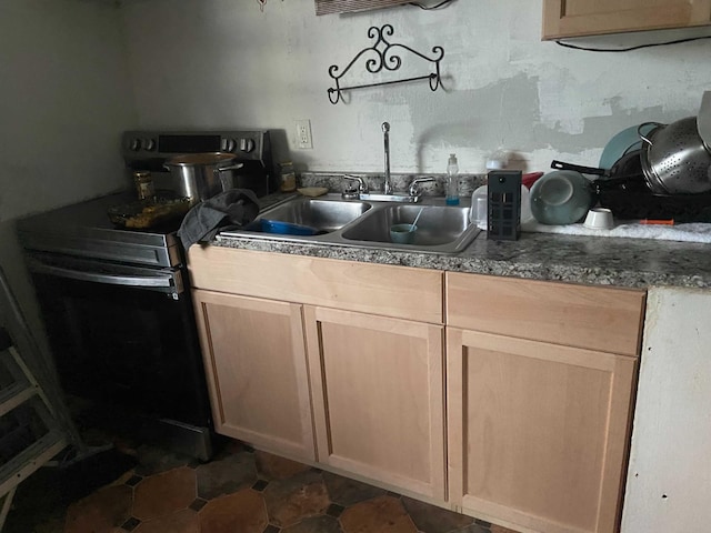 kitchen with dark tile patterned flooring, sink, range with electric stovetop, and light brown cabinetry