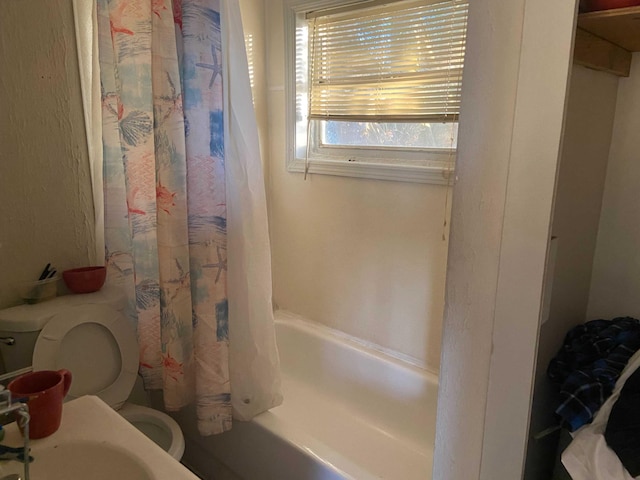 bathroom featuring shower / tub combo and toilet