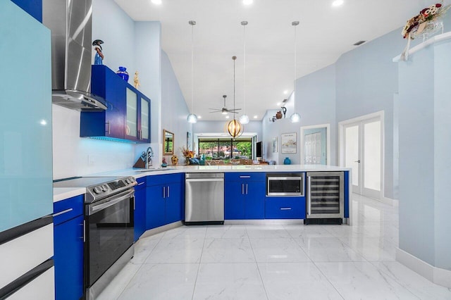 kitchen with wine cooler, wall chimney exhaust hood, a towering ceiling, stainless steel appliances, and kitchen peninsula