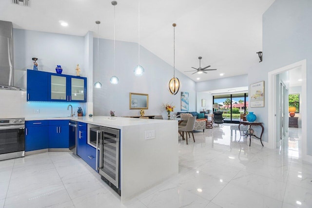 kitchen with light tile patterned flooring, high vaulted ceiling, decorative light fixtures, range, and beverage cooler