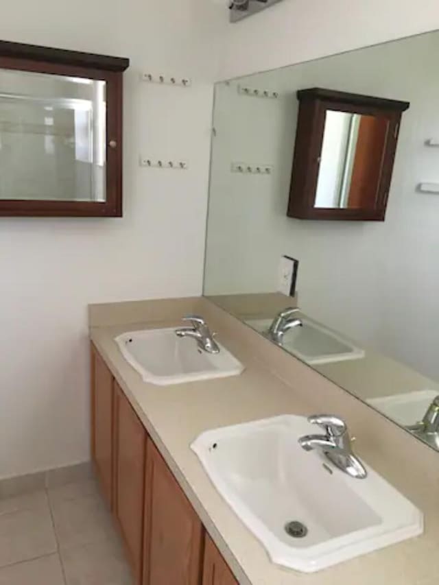 bathroom with tile patterned floors and double vanity