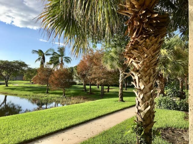 view of property's community featuring a lawn and a water view