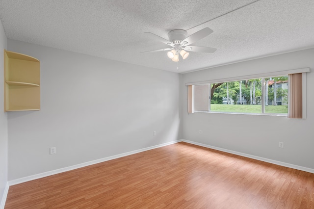 spare room with ceiling fan, hardwood / wood-style flooring, and a textured ceiling