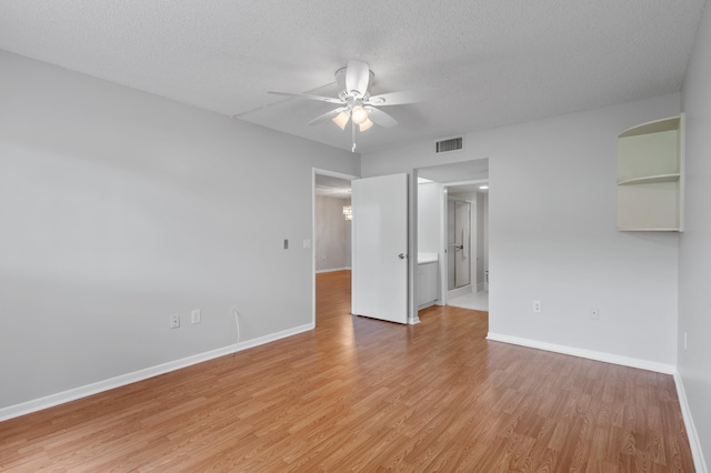 spare room with ceiling fan, light wood-type flooring, and a textured ceiling