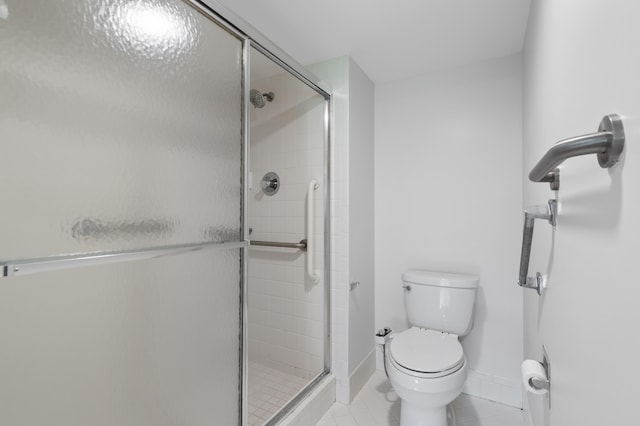 bathroom featuring walk in shower, tile patterned floors, and toilet