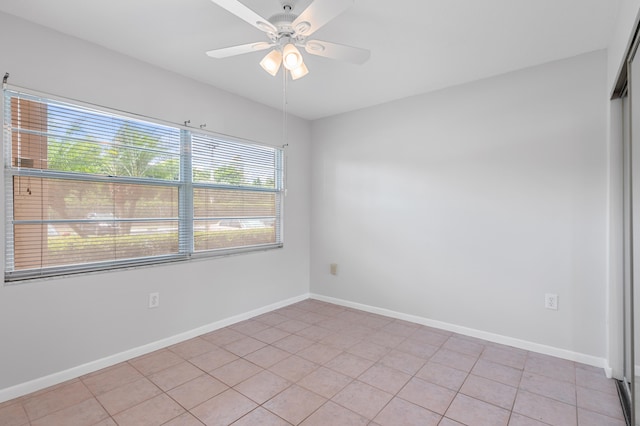 spare room featuring light tile patterned floors, ceiling fan, and a wealth of natural light