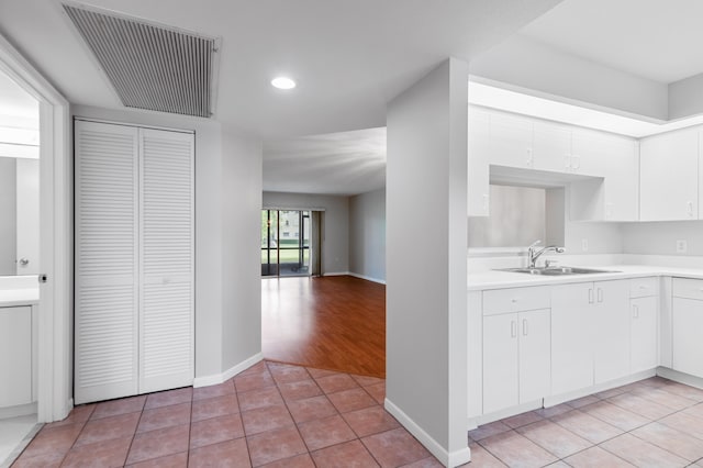 kitchen with white cabinets, sink, and light tile patterned floors