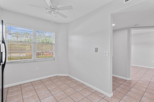 spare room with ceiling fan and light tile patterned flooring