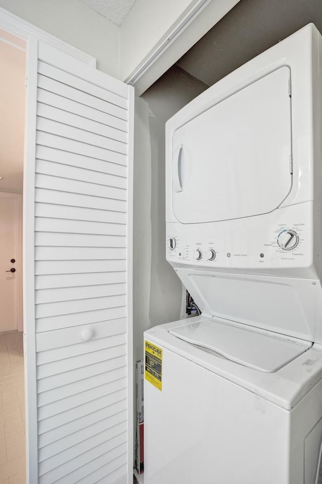 laundry area featuring stacked washer / drying machine