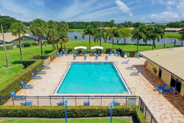 view of pool with a water view, a yard, and a patio