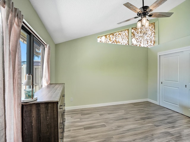 unfurnished dining area with ceiling fan, a healthy amount of sunlight, vaulted ceiling, and light hardwood / wood-style floors