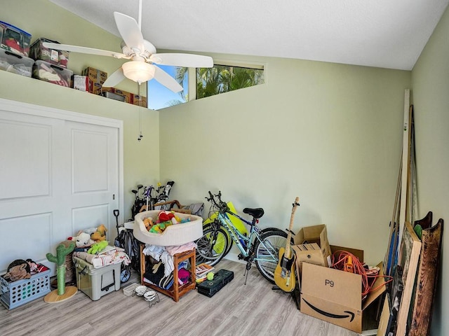 rec room featuring light hardwood / wood-style floors, vaulted ceiling, and ceiling fan