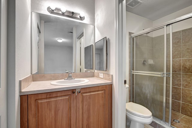 bathroom featuring vanity, an enclosed shower, and toilet