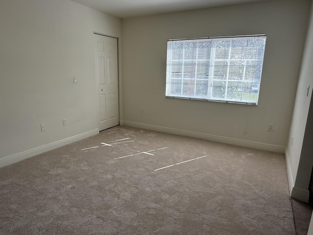 unfurnished bedroom with light carpet and a closet