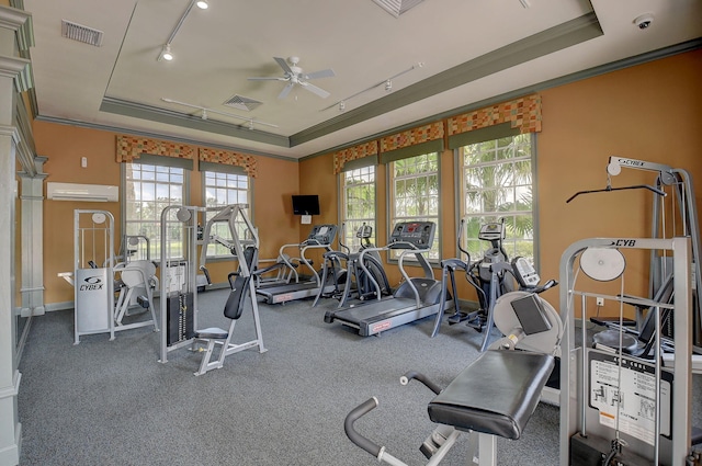 gym featuring ornamental molding, a wall mounted air conditioner, and a tray ceiling