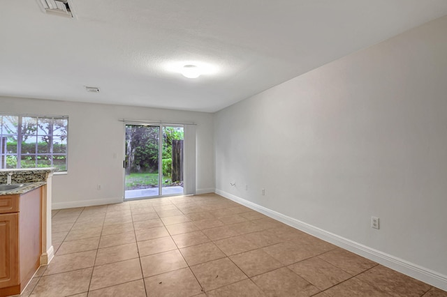 empty room with light tile patterned floors and sink