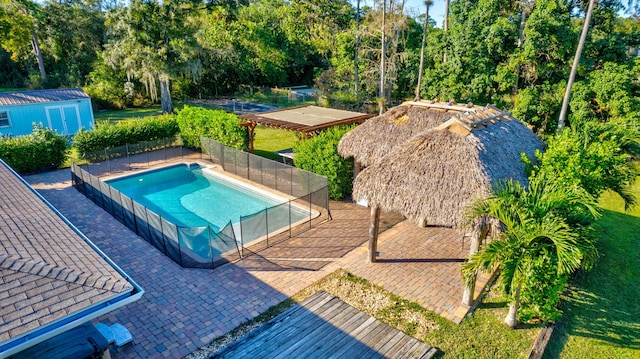 view of swimming pool with a patio area and a storage unit