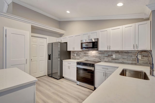 kitchen with white cabinetry, sink, stainless steel appliances, and vaulted ceiling