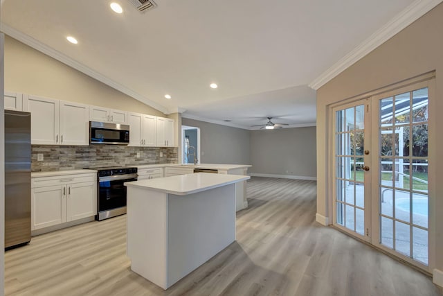 kitchen featuring crown molding, sink, a kitchen island, kitchen peninsula, and stainless steel appliances