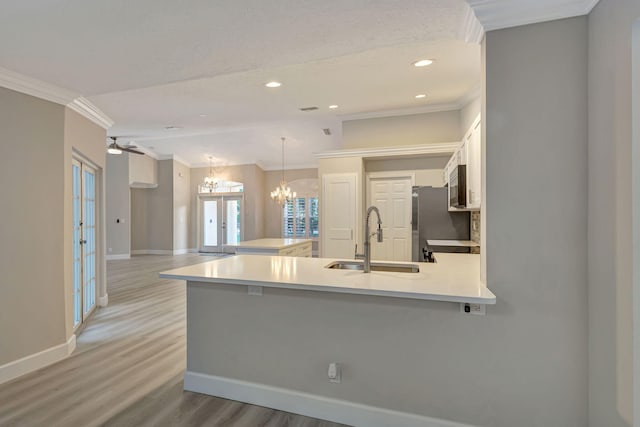 living room with ceiling fan, ornamental molding, and light wood-type flooring