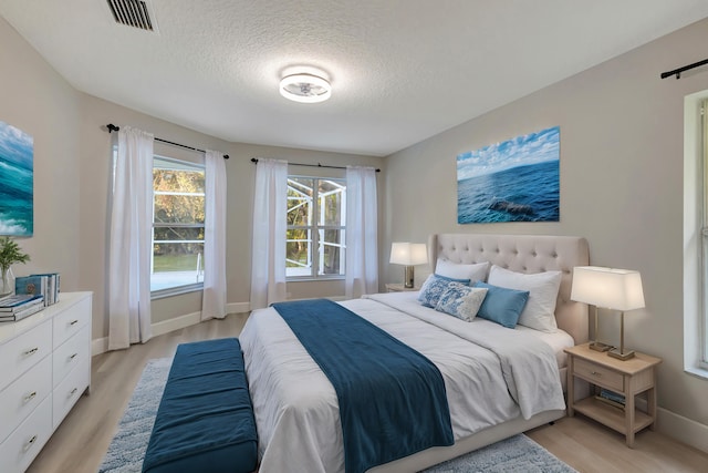 unfurnished room featuring a textured ceiling and light hardwood / wood-style floors