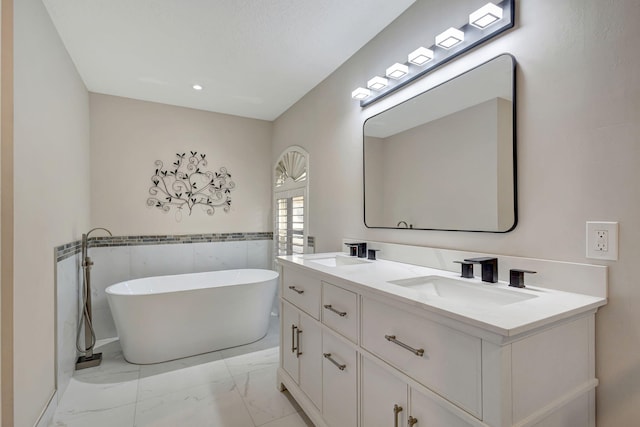 bathroom with a tub, vanity, and tile walls