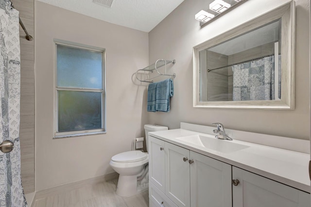 bathroom featuring a textured ceiling, vanity, toilet, and curtained shower