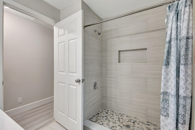 bathroom with walk in shower, a textured ceiling, and hardwood / wood-style flooring