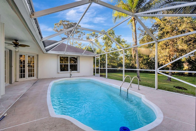 view of swimming pool with a lawn, a patio area, and glass enclosure