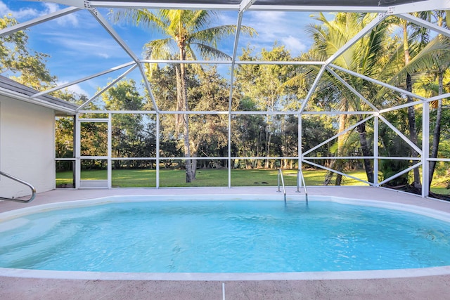 view of pool with a lawn and a lanai