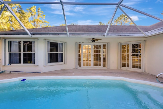 view of swimming pool featuring ceiling fan, a lanai, and french doors