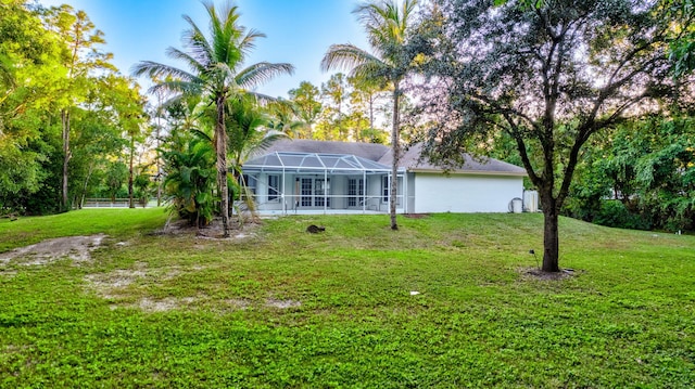 rear view of house featuring a lanai and a yard