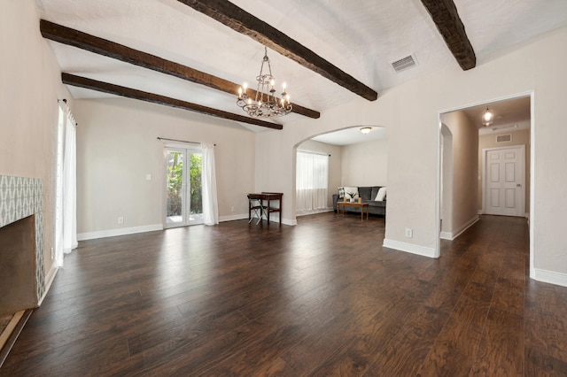 unfurnished living room featuring dark wood-type flooring, a chandelier, and beam ceiling