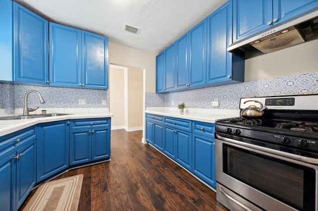 kitchen with sink, blue cabinets, dark hardwood / wood-style flooring, stainless steel gas stove, and decorative backsplash