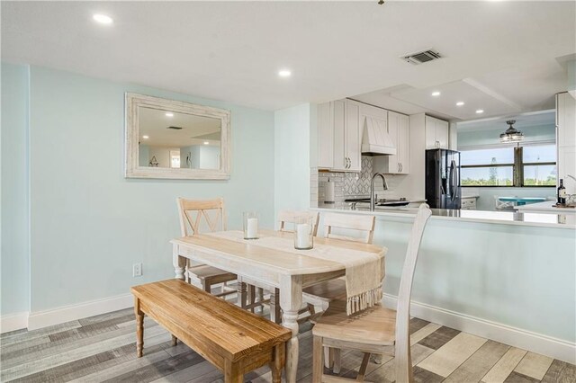 dining area with light wood-type flooring and sink