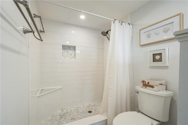 bathroom featuring toilet and curtained shower