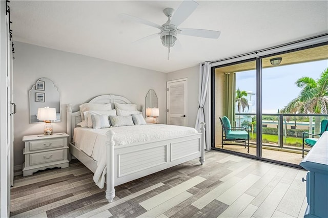 bedroom with hardwood / wood-style flooring, access to exterior, multiple windows, and ceiling fan