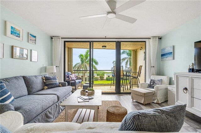 living room featuring ceiling fan and light hardwood / wood-style flooring