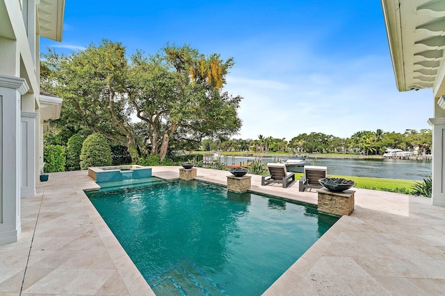 view of pool with a patio, an in ground hot tub, and a water view