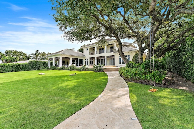 neoclassical home featuring a balcony and a front lawn